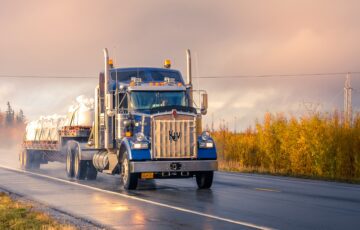 blue semi truck driving on road