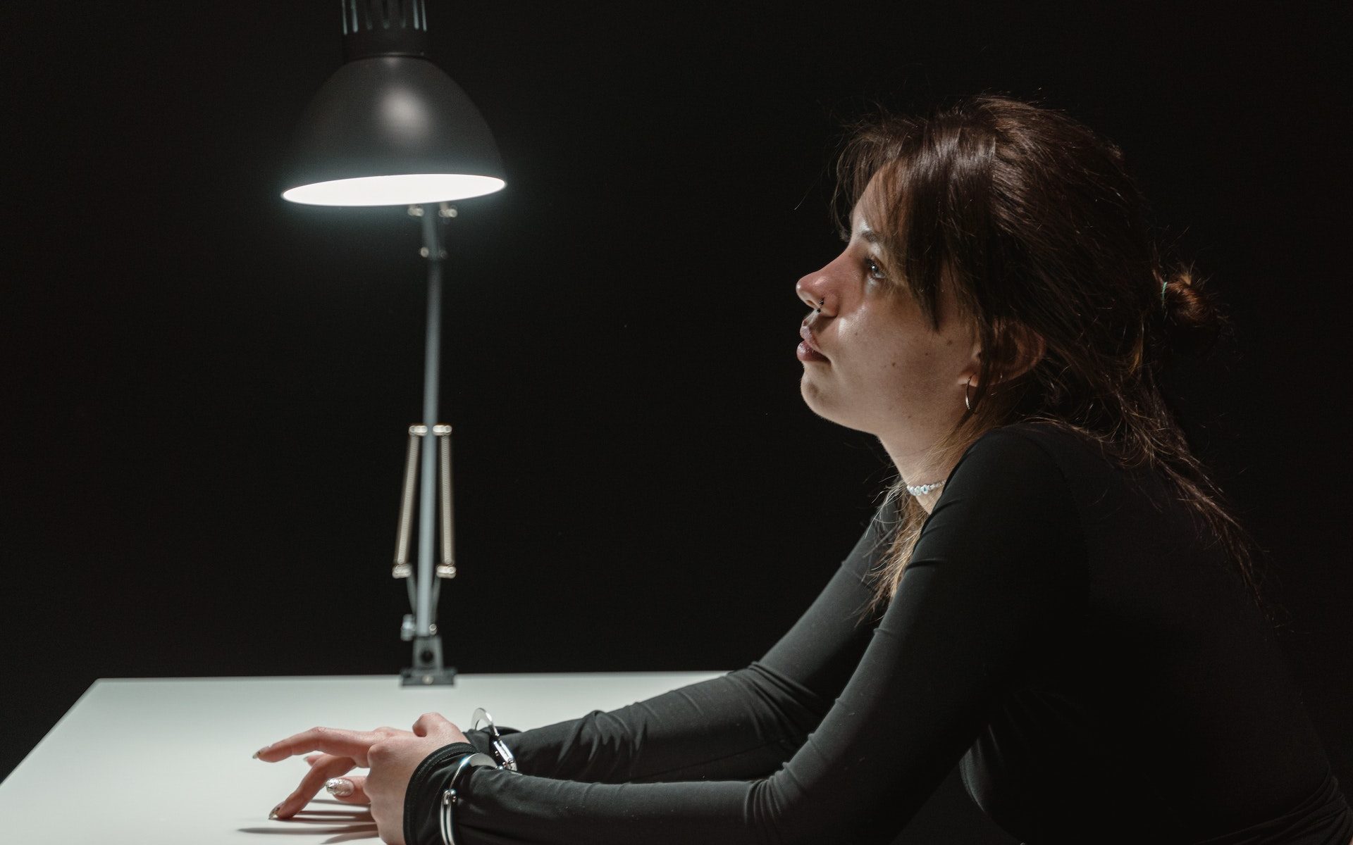 woman under lights being interrogated