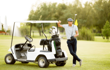 Man standing by golf cart on the green Stechschulte Nell Law