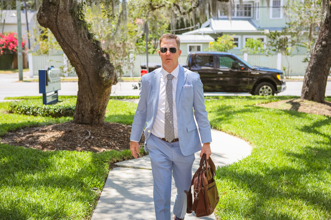 Ben in suit and tie walking into office