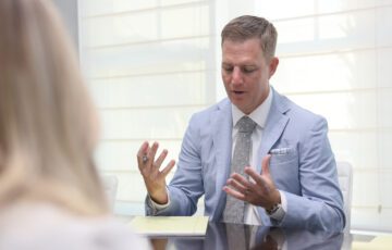 Ben in a light blue suit talking to a client