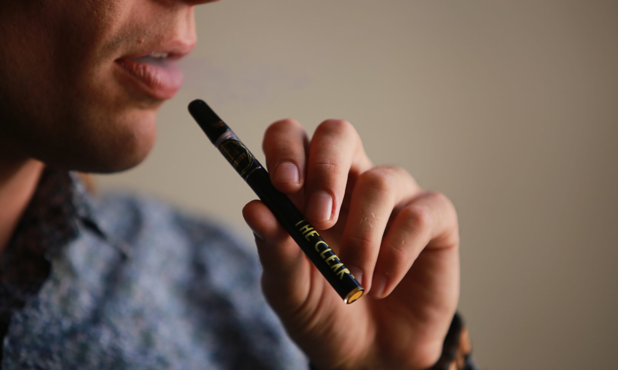 person using a cannabis concentrate pen to smoke