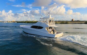 white yacht in the water with people fishing off the back