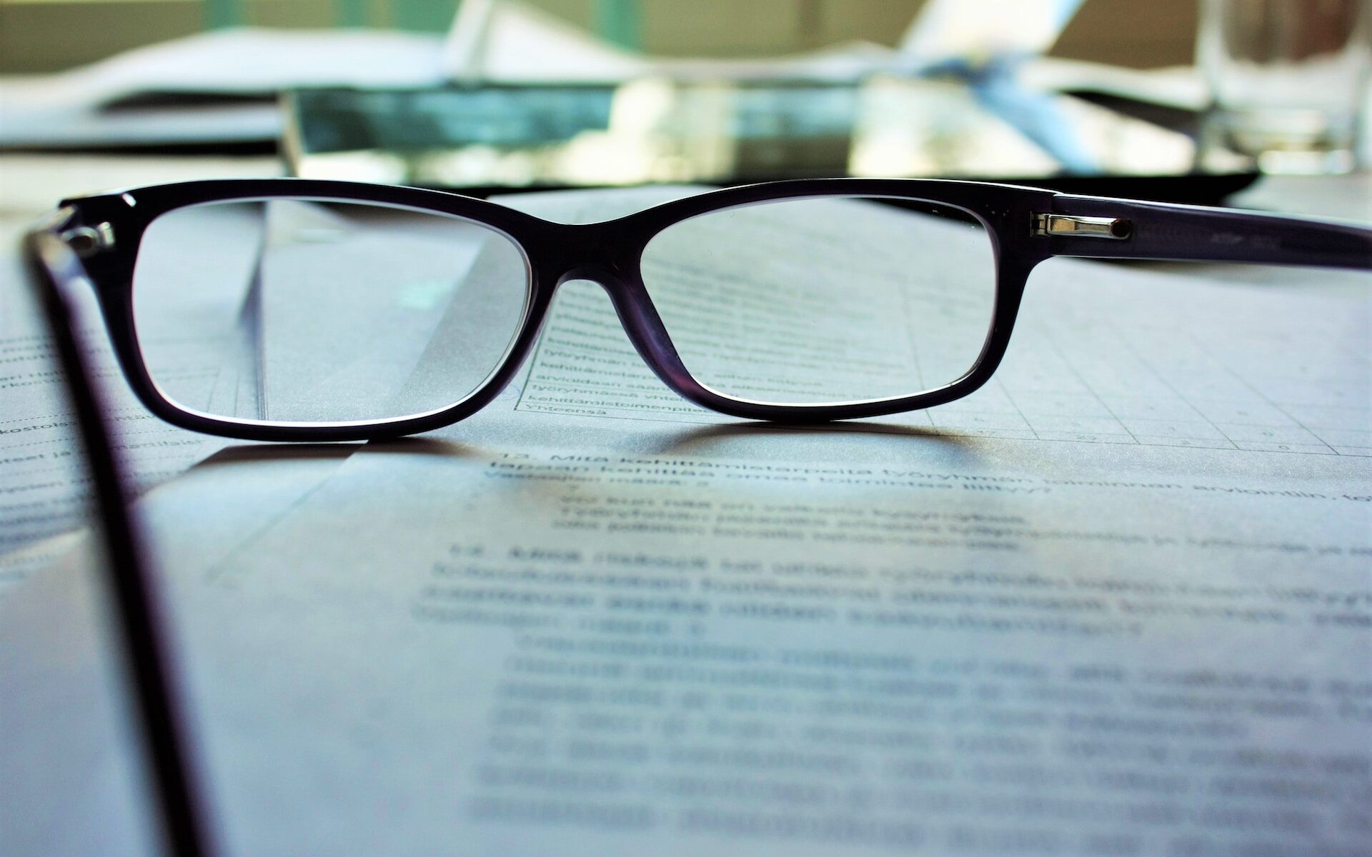 black framed glasses sitting on document