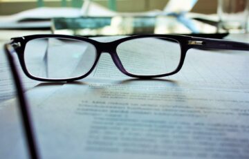 black framed glasses sitting on document