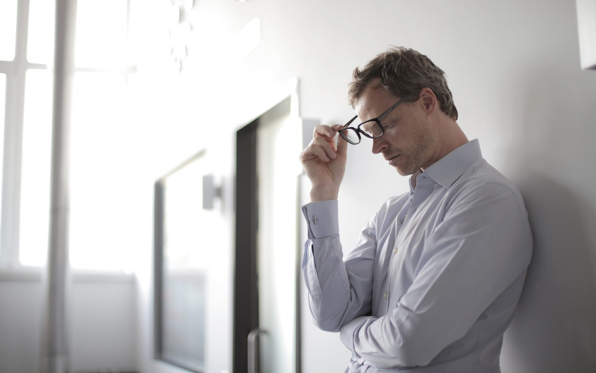man taking glasses off head PPP load fraud Stechschulte Nell Law
