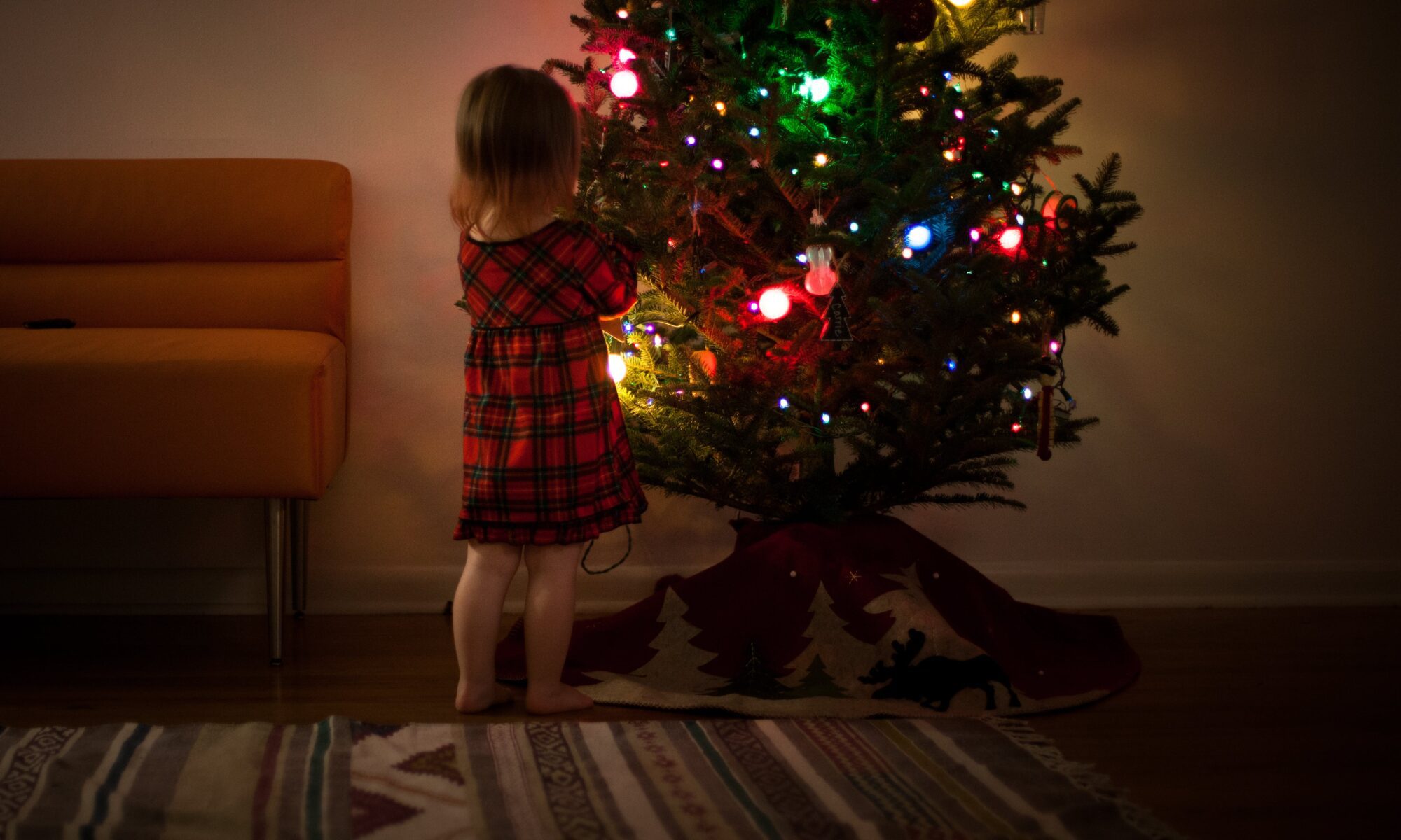 young girl in front of Christmas tree