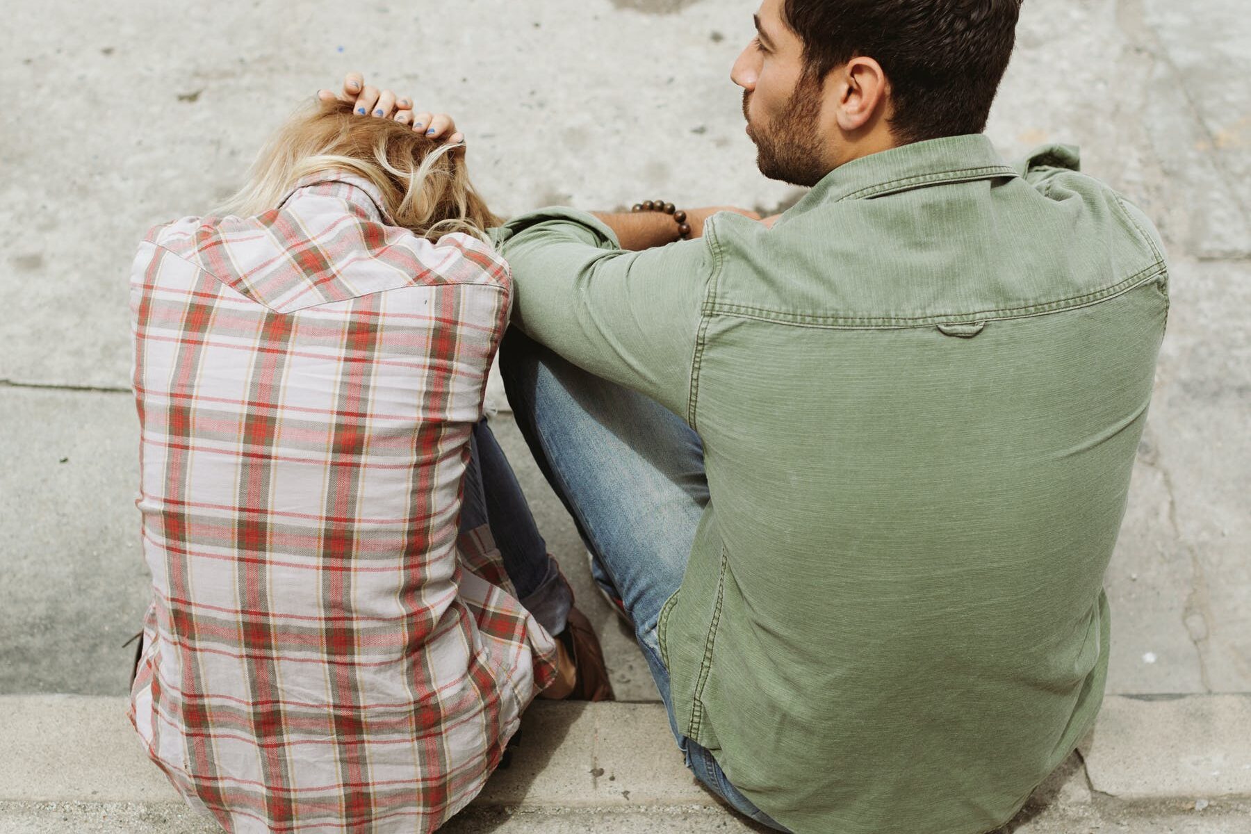 man and woman sitting next to each other after a domestic disturbance