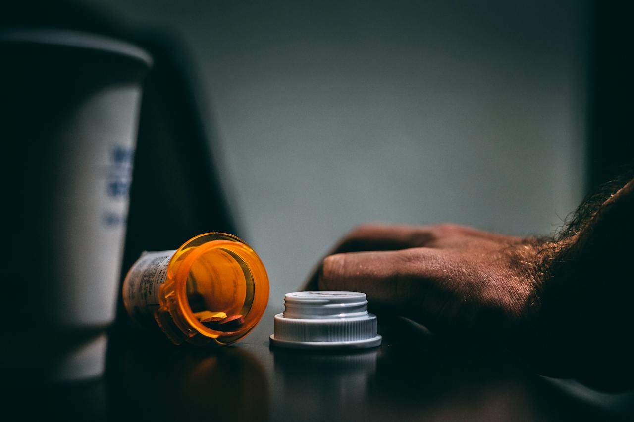 hand with pill bottle in dark room