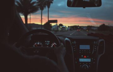 person driving car at night at sunset