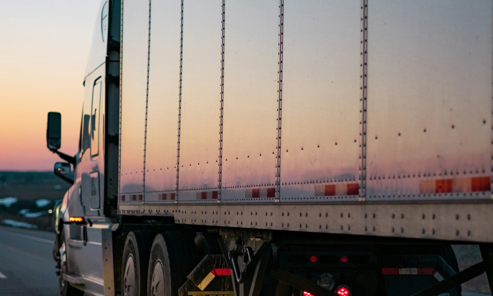 commercial truck driving at sunset