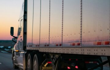 commercial truck driving at sunset