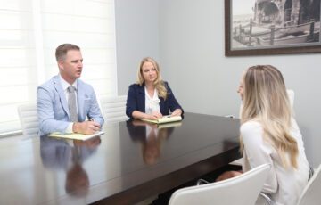 Ben and Amy sitting at conference desk with client