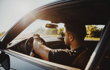 man driving a car during the day